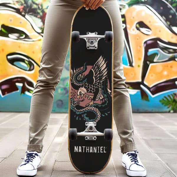 Person Holding A Skateboard With An Eagle And Snake Graphic And The Name Nathaniel.