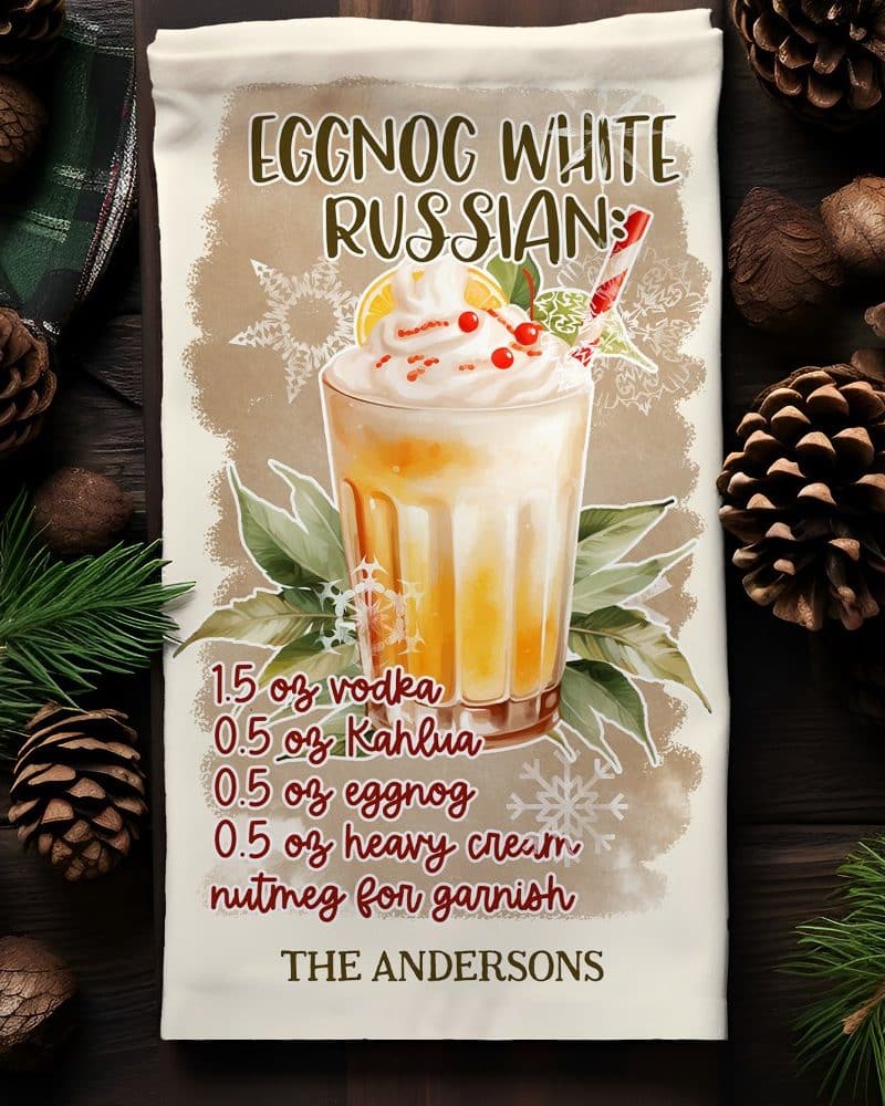 A kitchen towel featuring a recipe for an Eggnog White Russian cocktail, illustrated with a drink in a glass and garnished with whipped cream and cranberries.