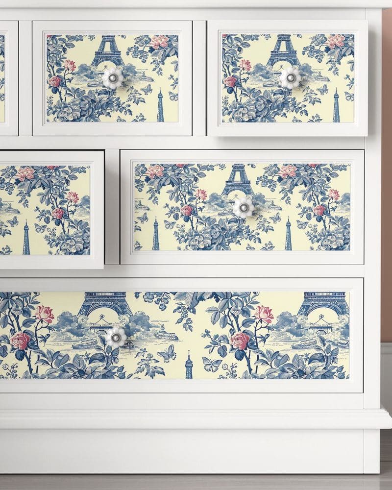 White dresser drawers with a blue and cream Parisian toile pattern.