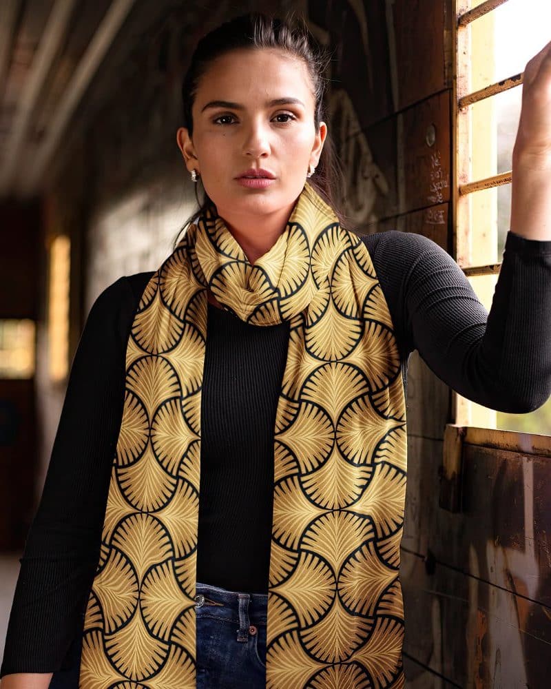 Woman wearing a gold and black patterned scarf.