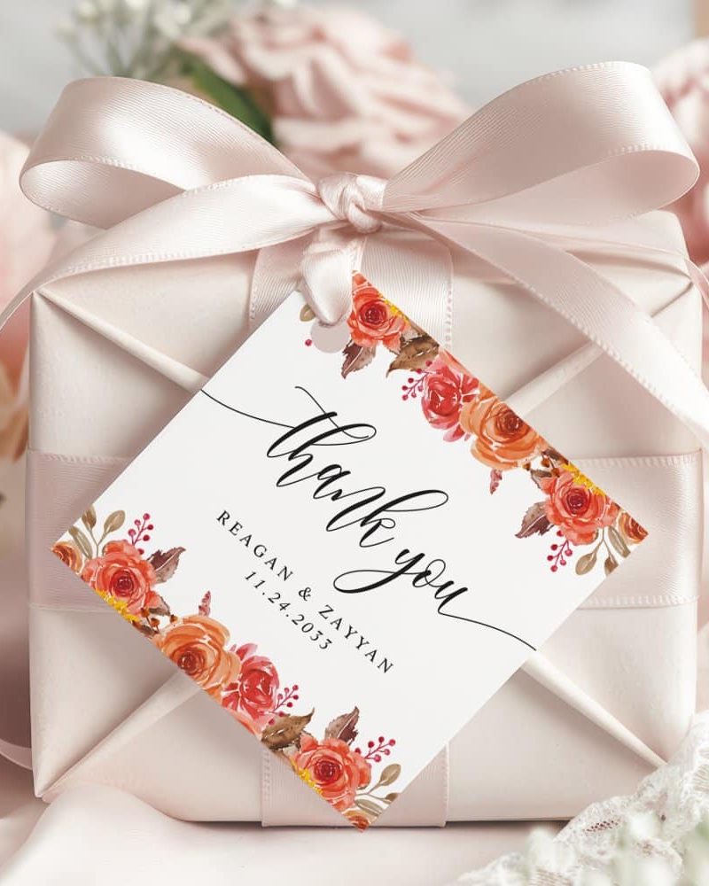 Wedding thank you gift tag with orange flowers and the couple's names and wedding date.