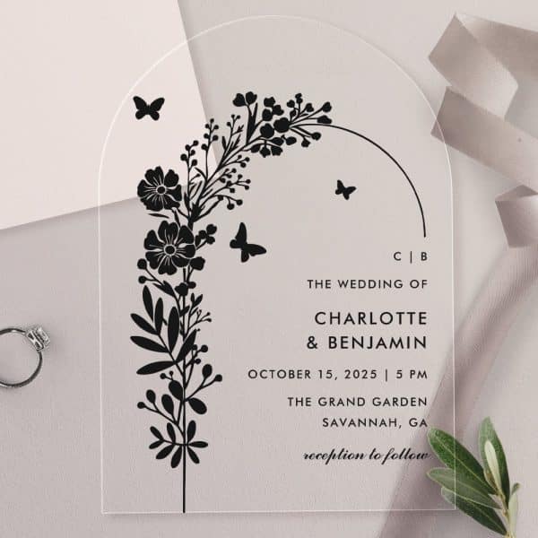 Clear Acrylic Wedding Invitation With Black Floral Design And Wedding Details.