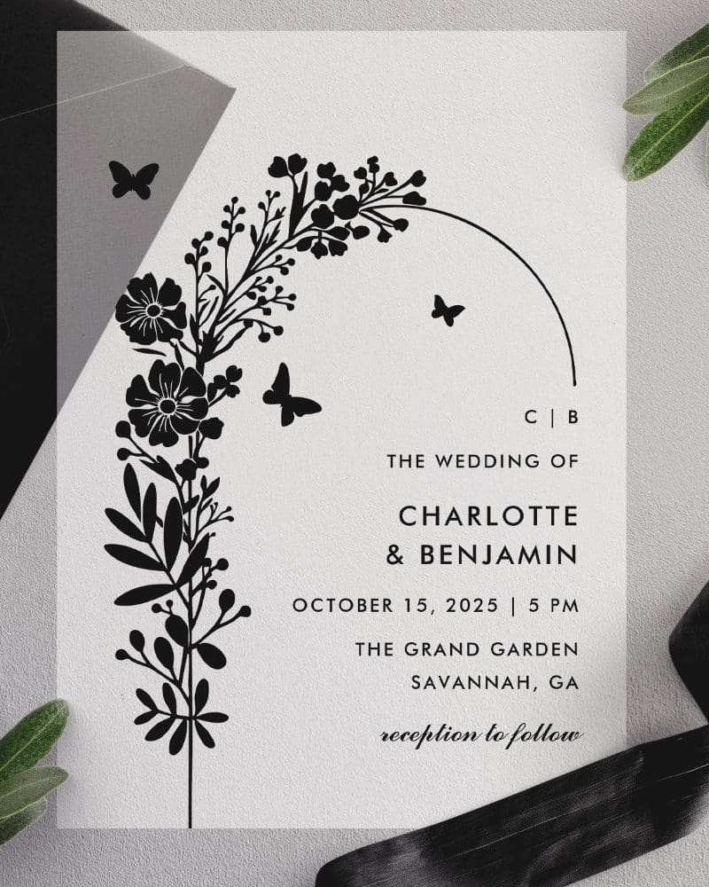 Black and white wedding invitation with floral design and butterflies.