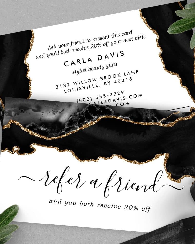Black and gold referral card for Carla Davis, stylist and beauty guru, offering 20% off for both referrer and friend.