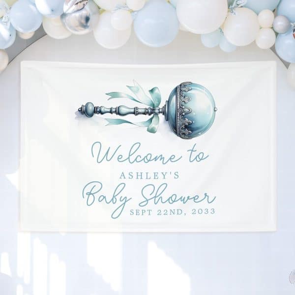 White Baby Shower Sign With A Blue Rattle Illustration And Ashley'S Name, Date.