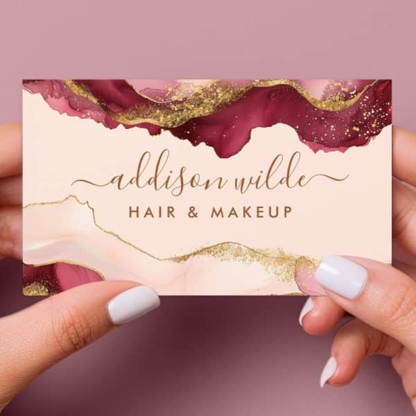 Business Card For Addison Wilde Hair &Amp; Makeup, Featuring A Burgundy And Gold Abstract Design.