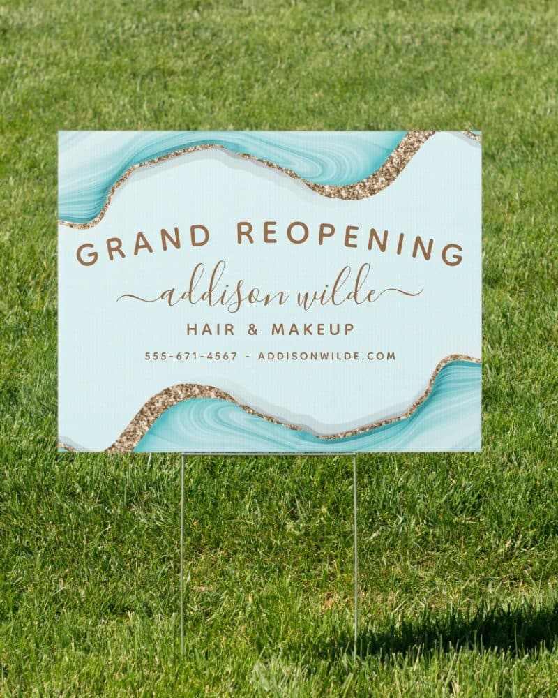 Grand reopening sign for Addison Wilde Hair & Makeup, featuring a teal and gold design.