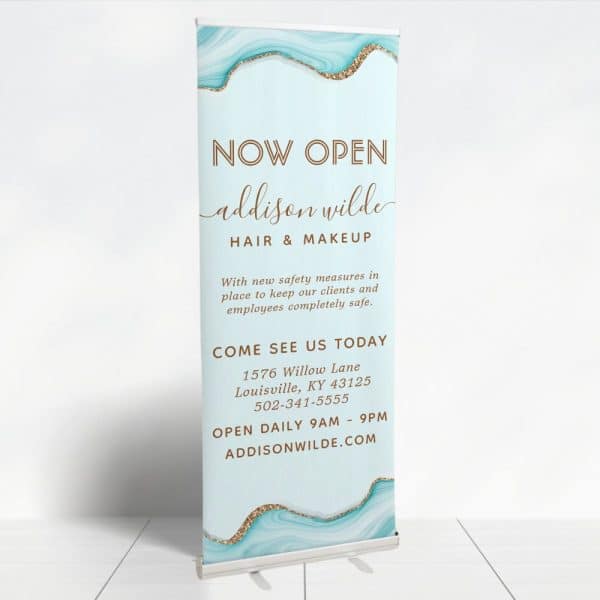 A Retractable Banner Announcing The Grand Opening Of Addison Wilde Hair &Amp; Makeup.