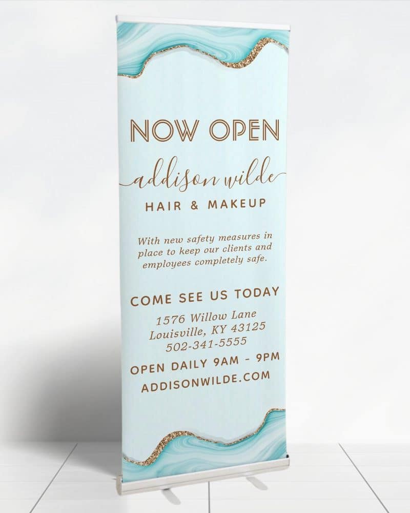 A retractable banner announcing the grand opening of Addison Wilde Hair & Makeup.