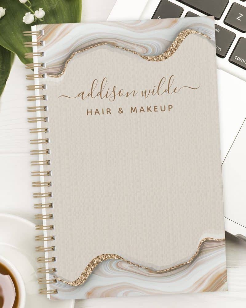 Spiral-bound notebook with an agate design and Addison Wilde Hair & Makeup text.