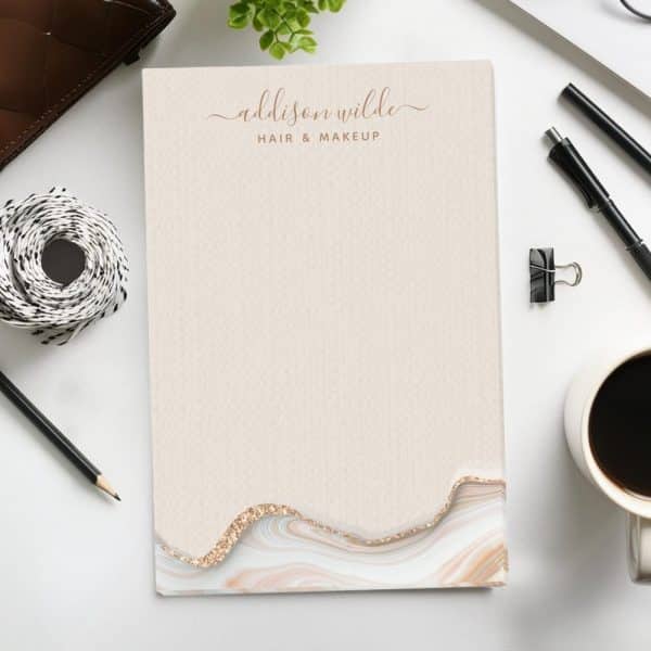 A Notepad With The Name Addison Wilde Hair &Amp; Makeup At The Top, And A Marble Design At The Bottom.
