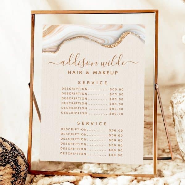 A Rose Gold Framed Sign Displaying Addison Wilde Hair &Amp; Makeup'S Price List, Featuring An Abstract Marble Design.
