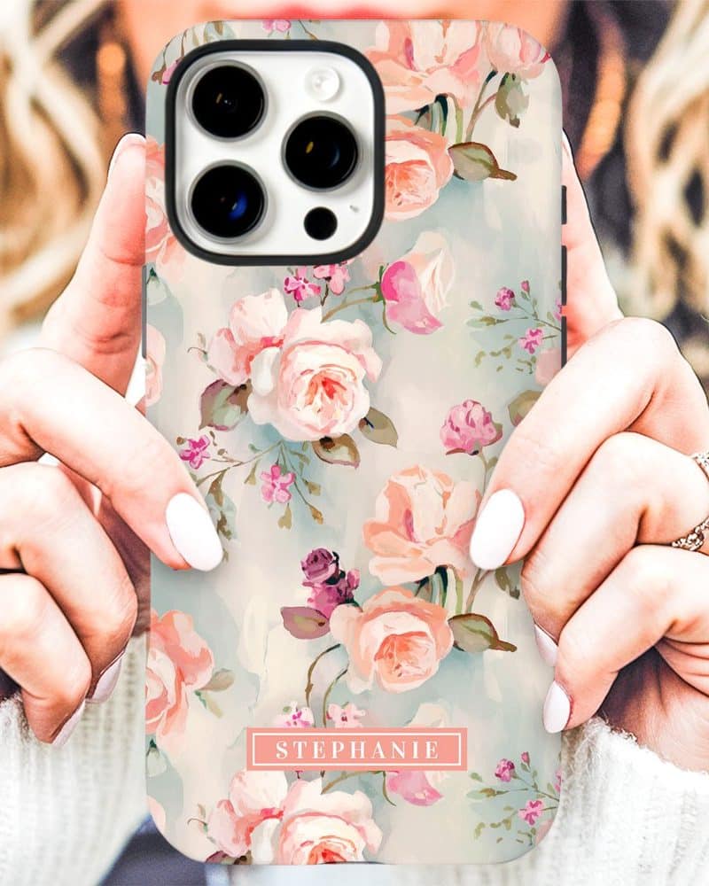 A woman's hands hold a phone case with a pastel floral pattern and the name Stephanie.