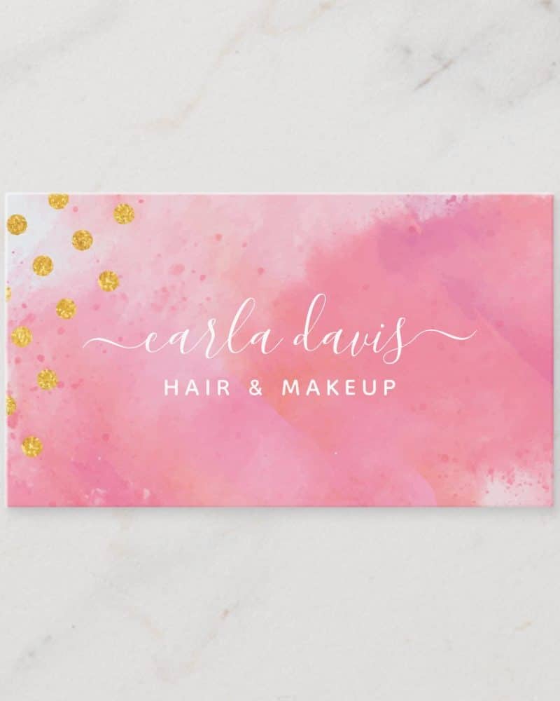 Pink watercolor business card with gold glitter and Carla Davis Hair & Makeup in elegant script.