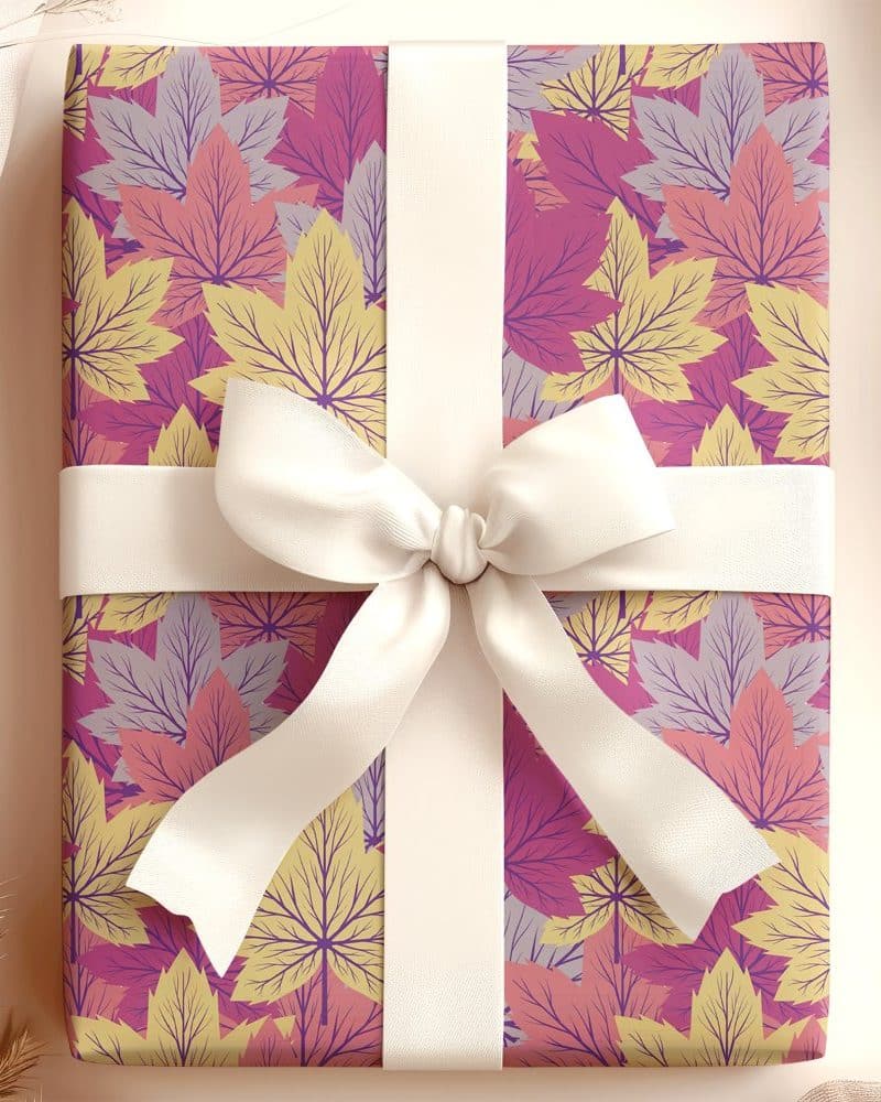 Gift box with autumn leaf pattern and white ribbon.