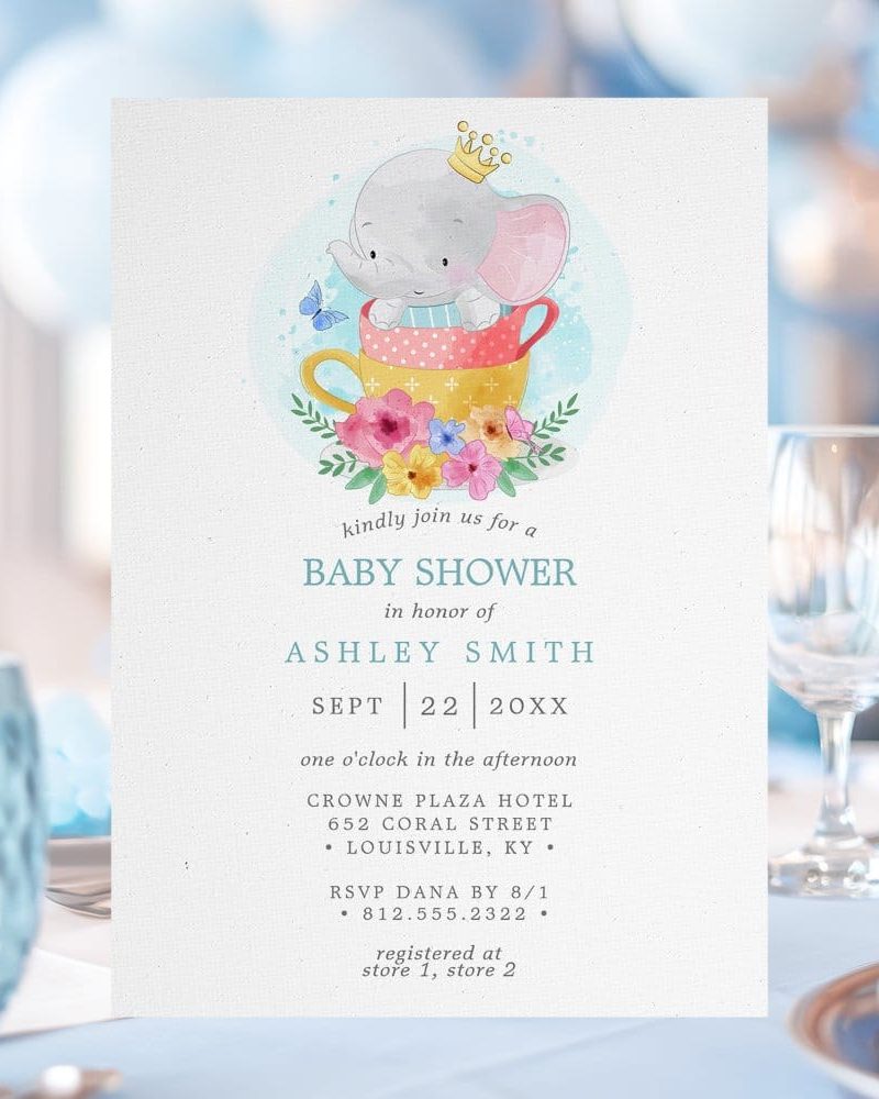 Baby shower invitation featuring a cartoon elephant wearing a crown and sitting in a teacup surrounded by flowers.