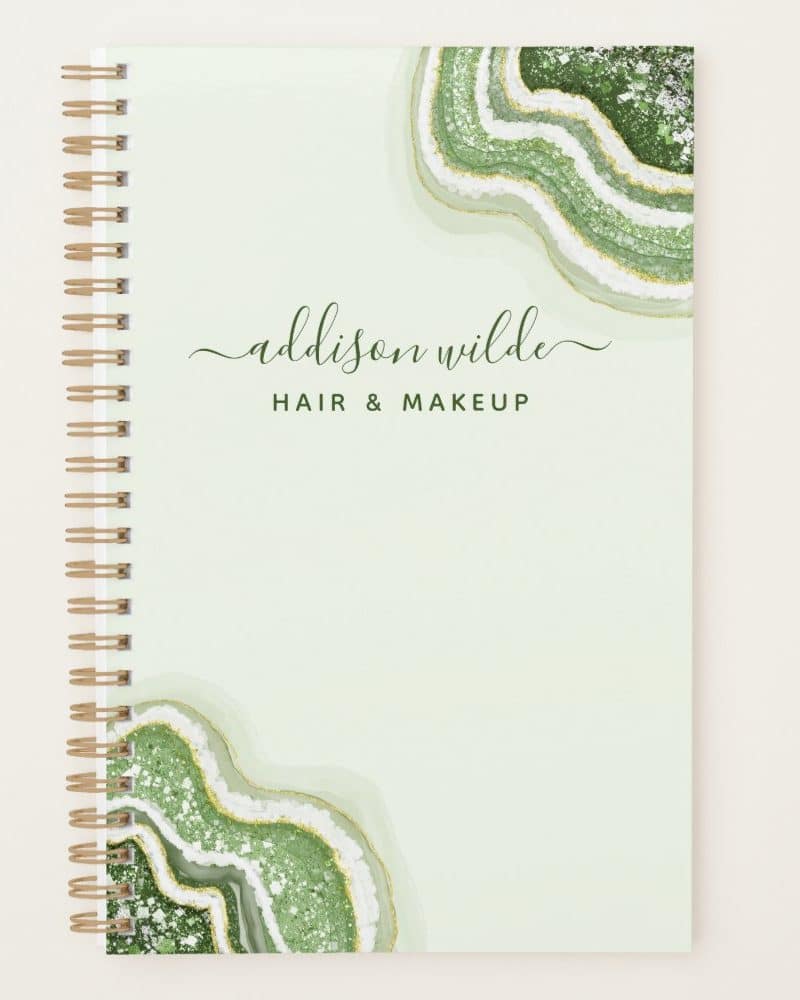 Spiral-bound notebook with a light green cover featuring green and gold agate designs and the name Addison Wilde Hair & Makeup.