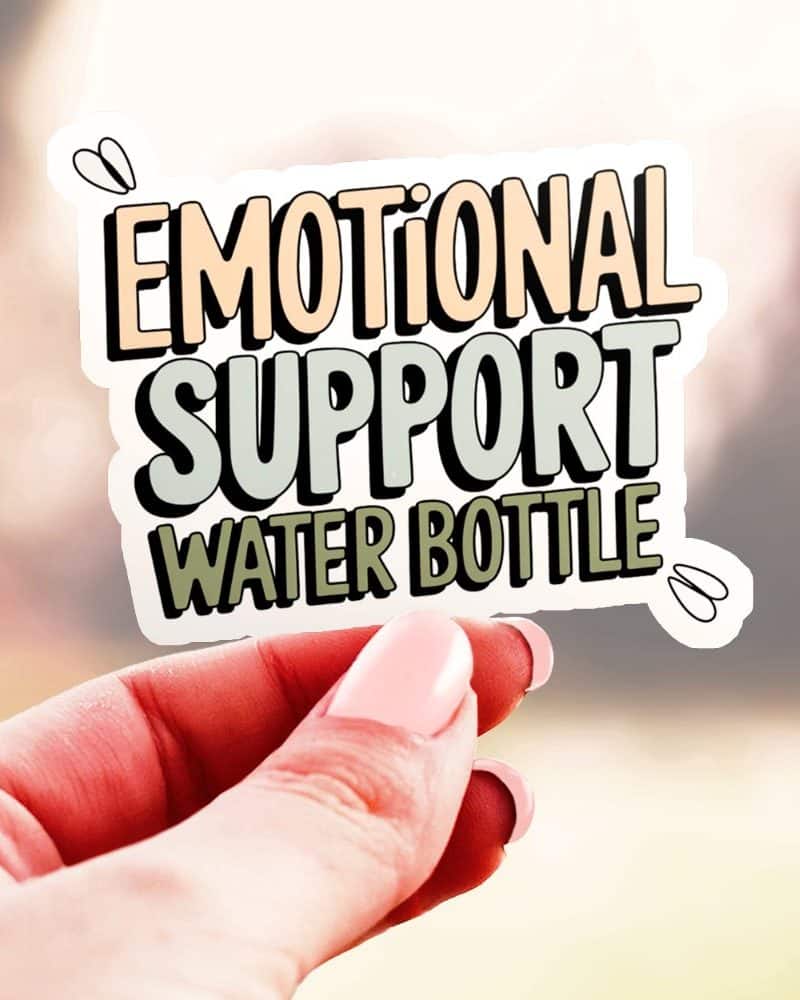 A hand holds up a sticker that reads Emotional Support Water Bottle. The text is stylized in pastel colors.