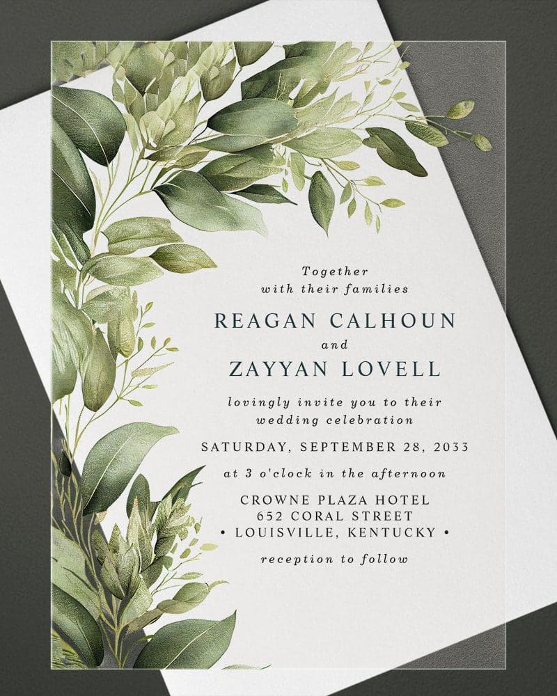 Wedding invitation with leafy green watercolor border and text announcing the marriage of Reagan Calhoun and Zayyan Lovell.