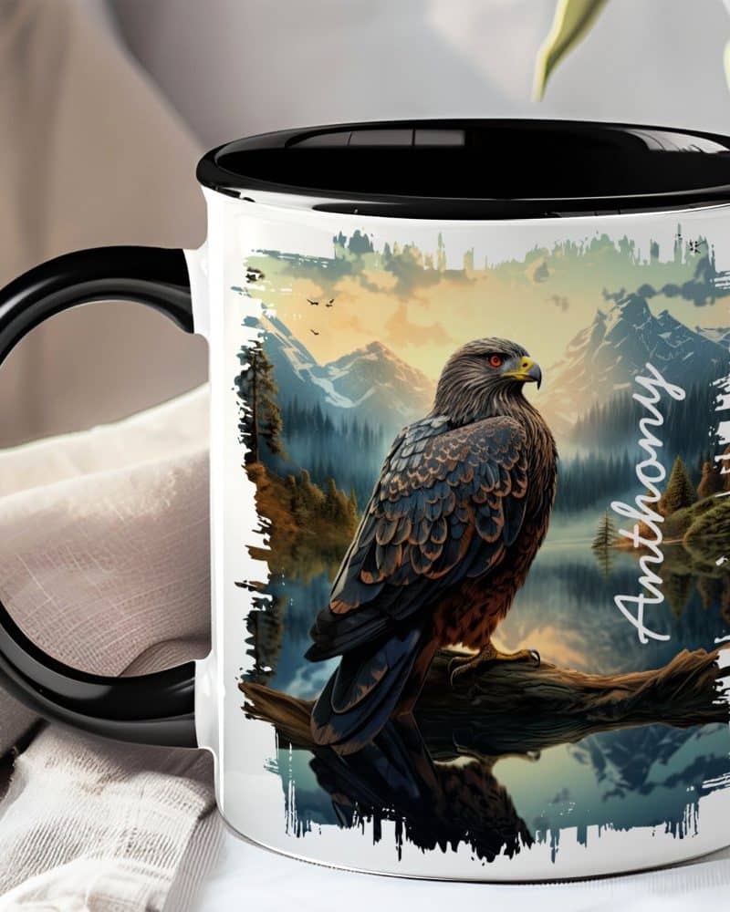 Black-handled mug with a personalized design featuring a hawk perched on a branch overlooking a mountain lake at sunset.