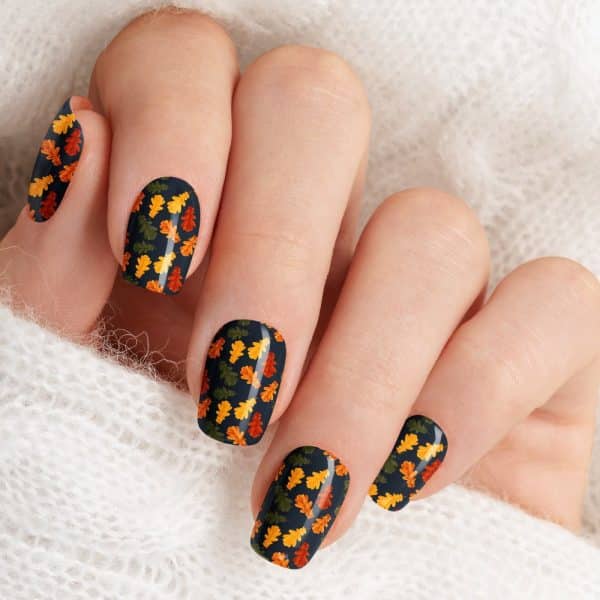 Close-Up Of A Hand With Nails Decorated With Autumn Leaf Designs.