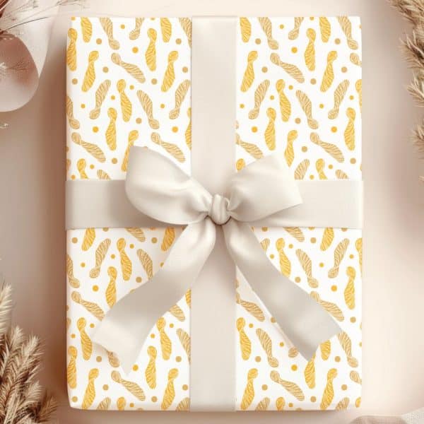 Gift Wrapped In White Paper With A Yellow Maple Seed Pattern And A Cream-Colored Ribbon.