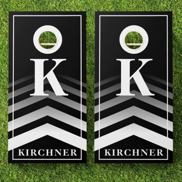 Pair Of Black Cornhole Boards With White Chevron Stripes, A Large White K, And The Name Kirchner.