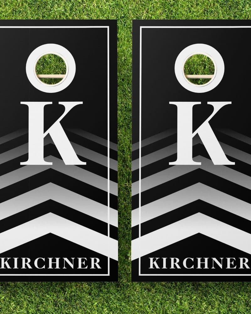 Pair of black cornhole boards with white chevron stripes, a large white K, and the name Kirchner.