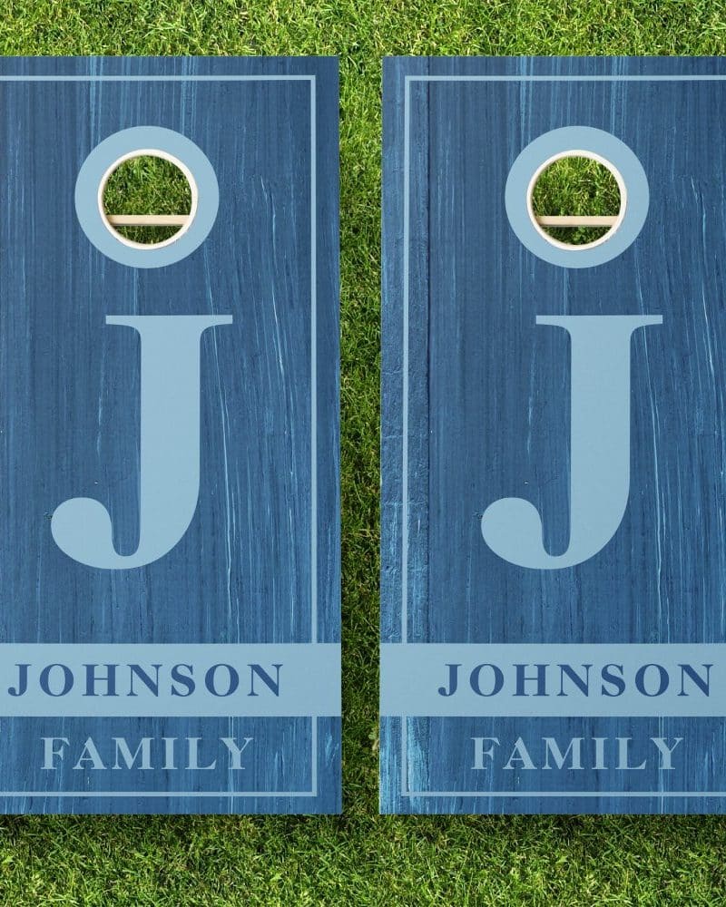 Pair of blue cornhole boards with the letter J and Johnson Family printed on them.