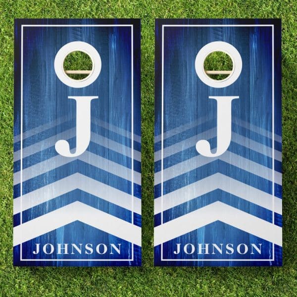 Pair Of Blue And White Personalized Cornhole Boards With Chevron Stripes, The Letter J, And The Name Johnson.