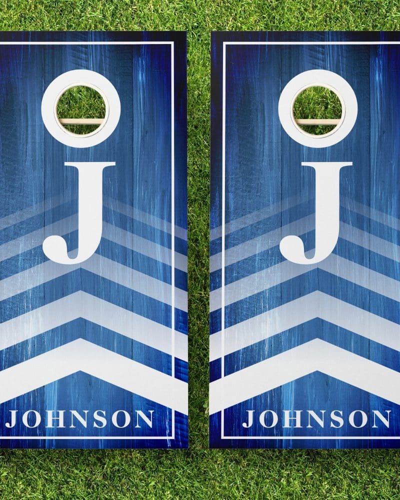 Pair of blue and white personalized cornhole boards with chevron stripes, the letter J, and the name Johnson.