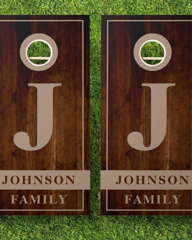 Pair of dark brown wooden cornhole boards with the letter J and Johnson Family.