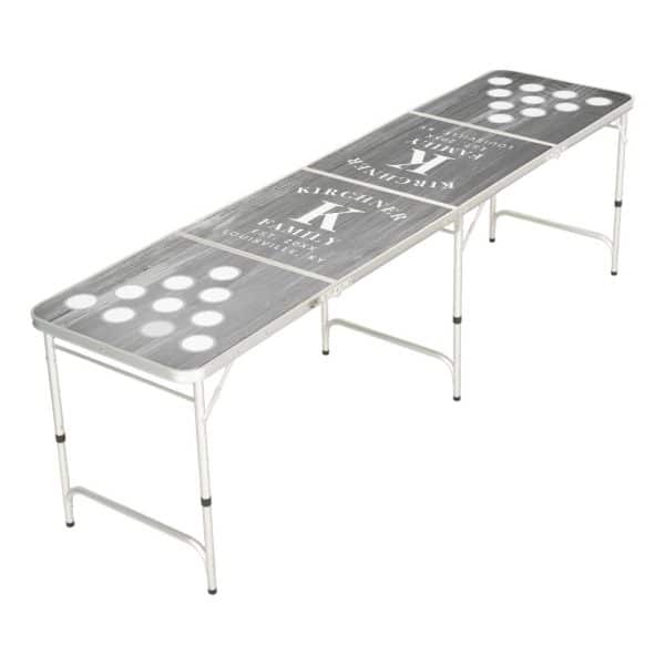 Gray Folding Beer Pong Table With A Wood Grain Design And A Family Name And Initial.