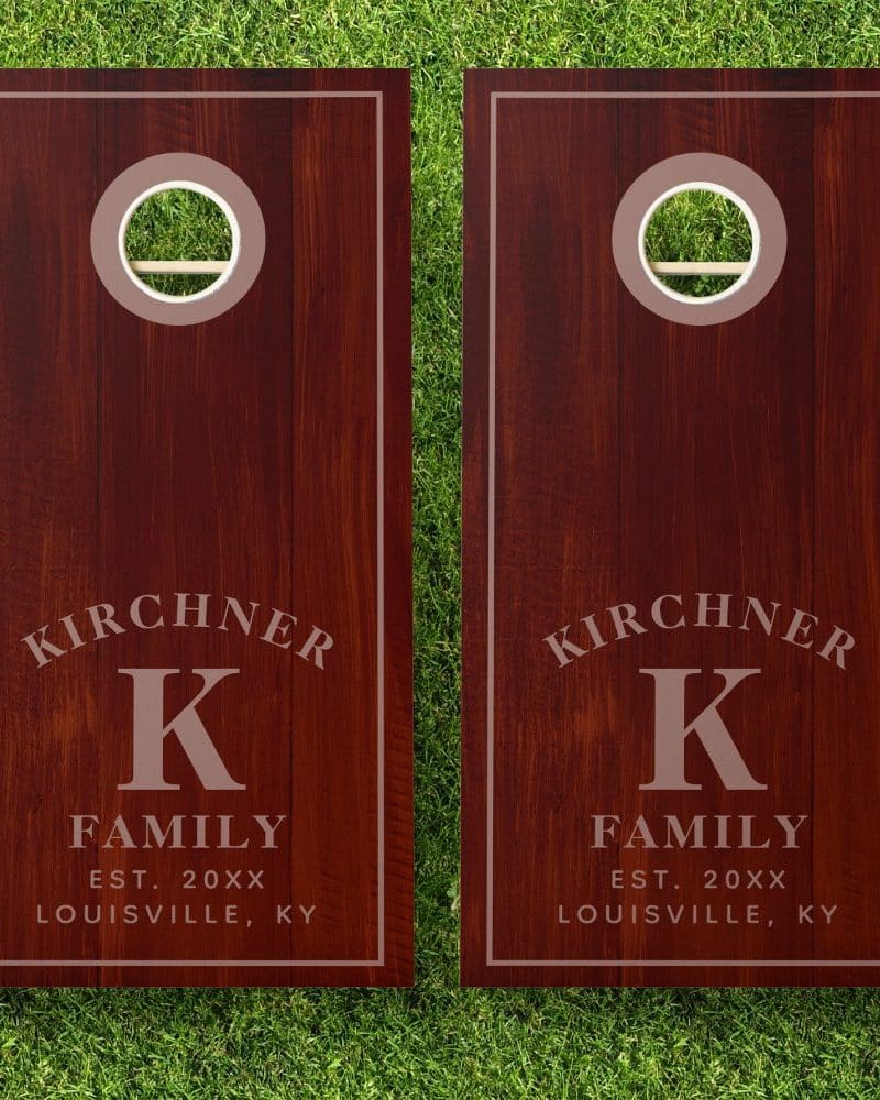 Pair of dark brown personalized cornhole boards with the Kirchner family name, initial K, and establishment year.