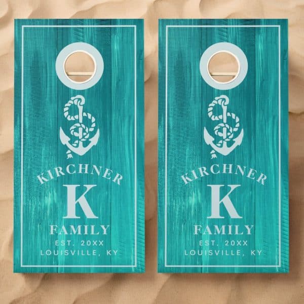 Pair Of Teal Cornhole Boards With A Nautical Anchor Design, Family Name, Initial, And Establishment Year.