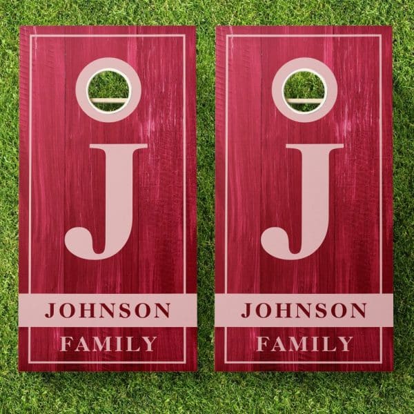 Two Dark Red Personalized Cornhole Boards With The Initial J And Johnson Family Displayed.