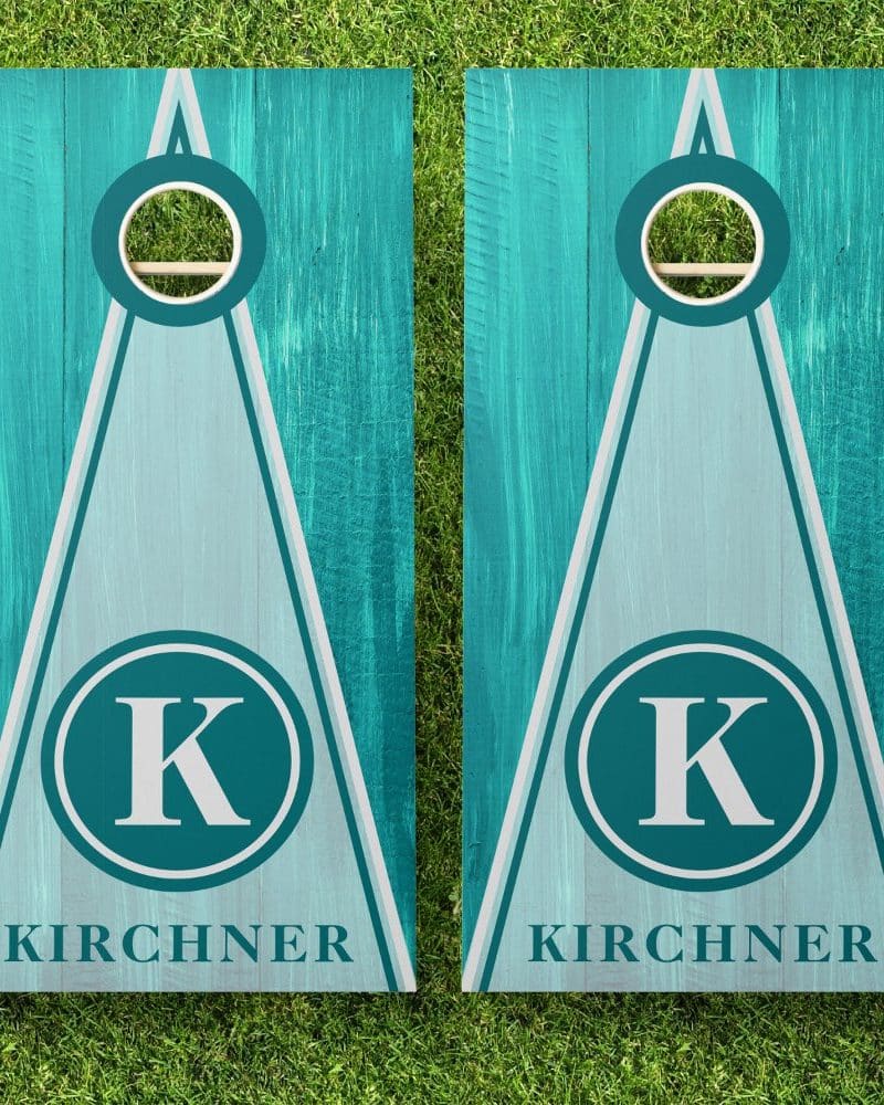 Pair of teal and light blue personalized cornhole boards with the initial K and the last name Kirchner.