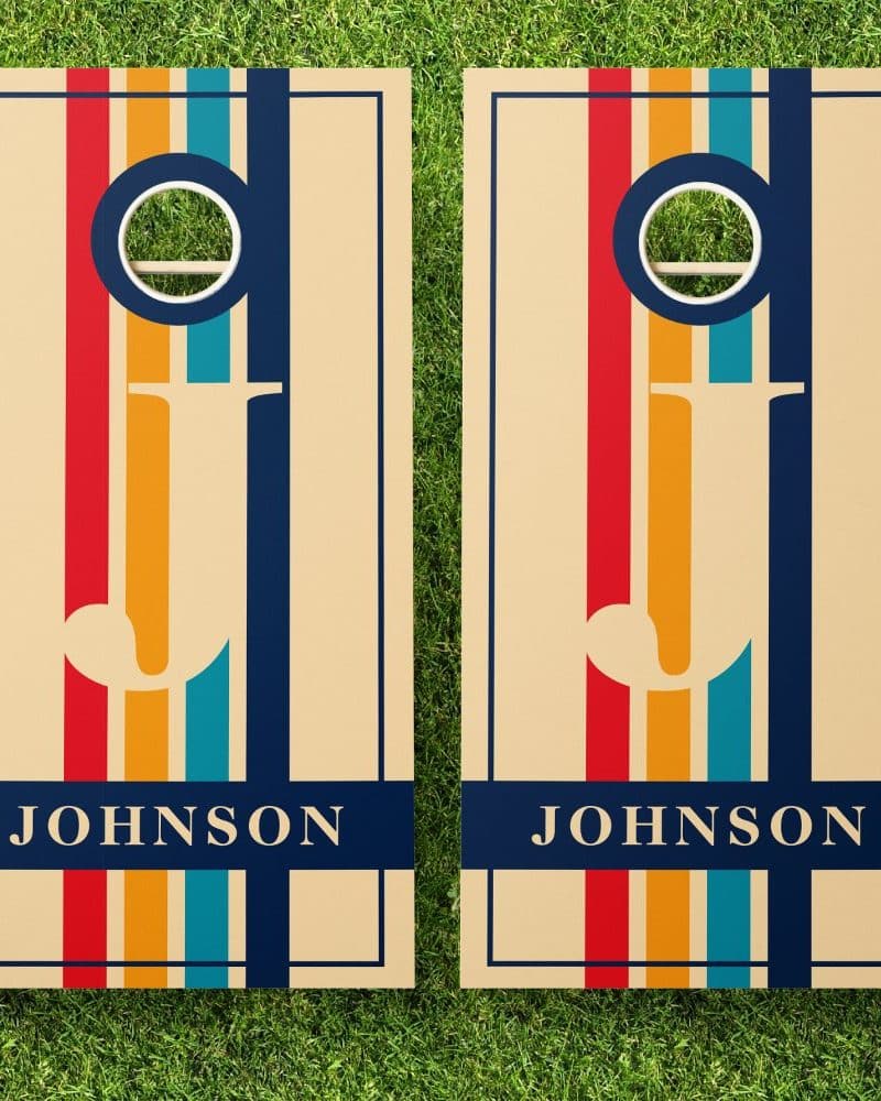 Pair of personalized beige cornhole boards with a retro striped design, the name Johnson at the bottom.
