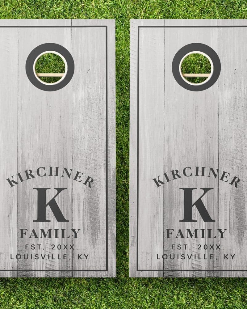 Pair of gray wooden cornhole boards with the Kirchner family name, initial K, establishment year, and city.
