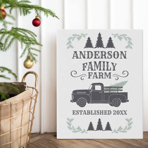 A White Sign With The Anderson Family Farm Logo. The Logo Features A Vintage Truck Carrying A Christmas Tree.
