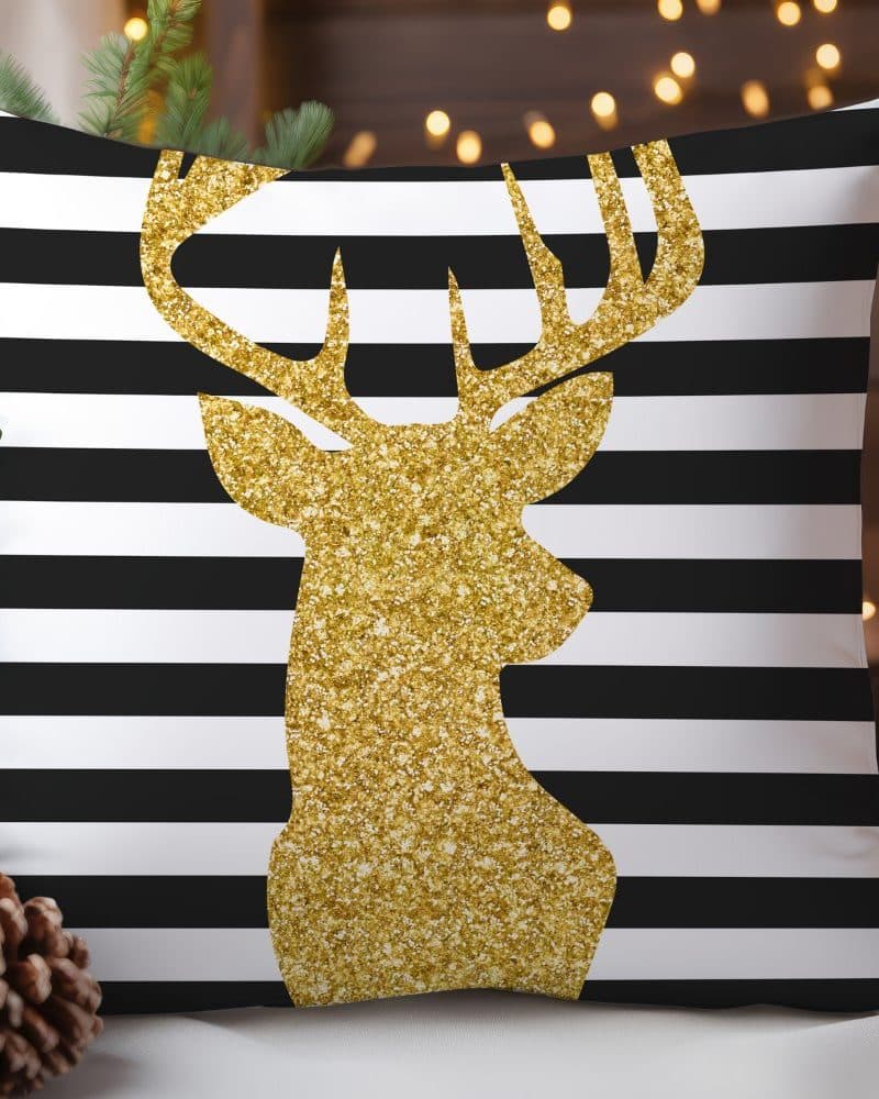 Gold glitter reindeer silhouette on black and white striped pillow.