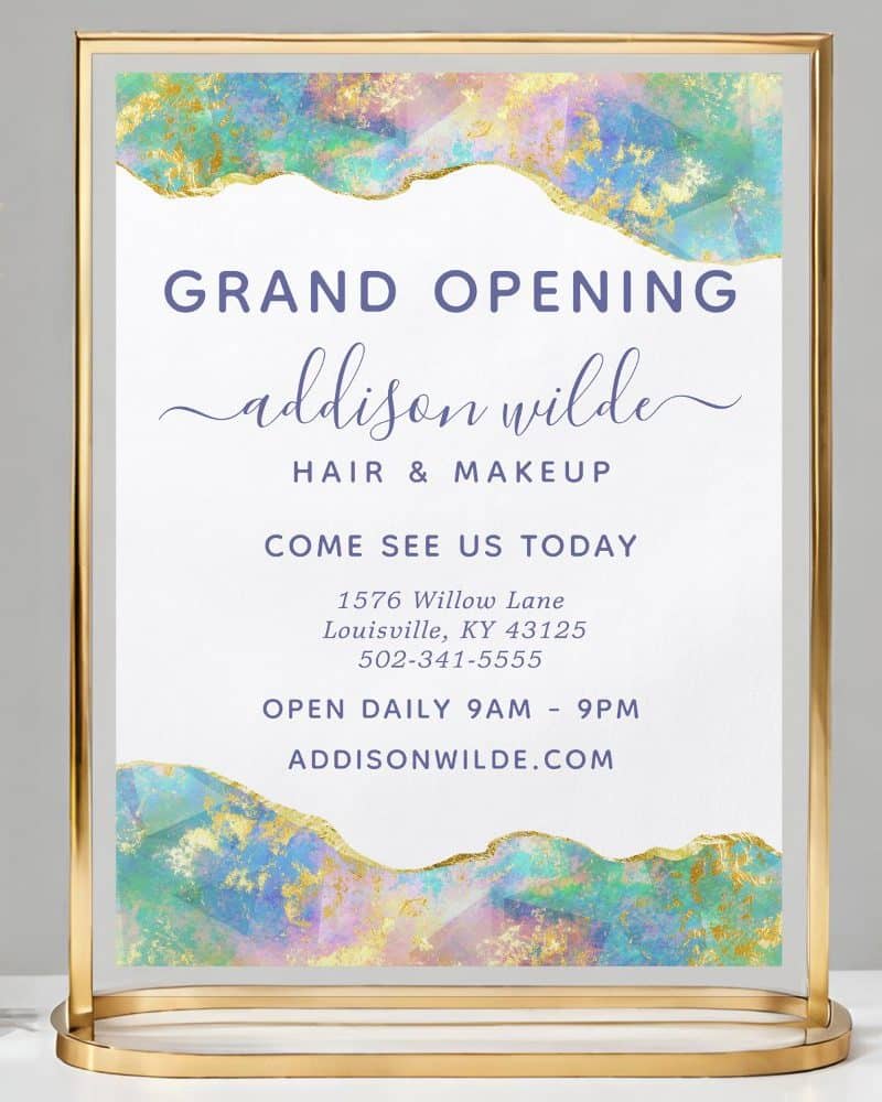 Grand opening sign for Addison Wilde Hair & Makeup, featuring an abstract watercolor design. The sign includes the business address, phone number, and website.