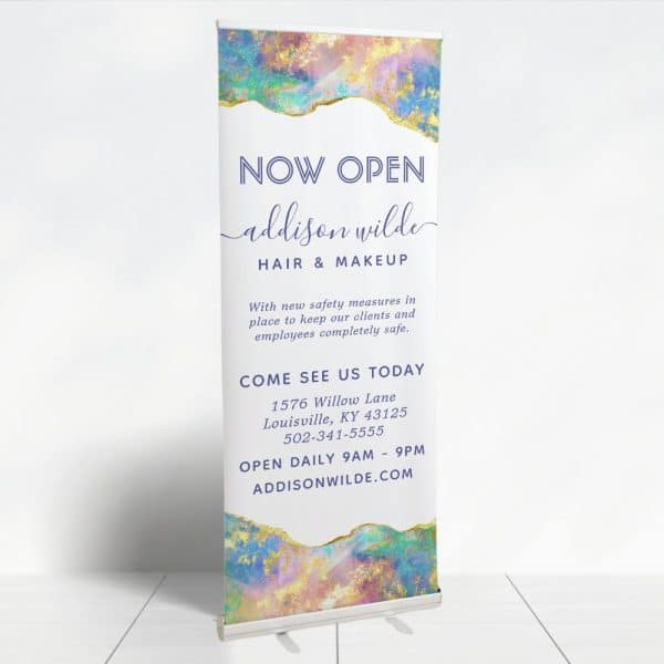 A Retractable Banner Announcing The Grand Opening Of Addison Wilde Hair &Amp; Makeup. The Banner Features A Pastel Abstract Design And Includes The Business'S Address, Phone Number, And Website.