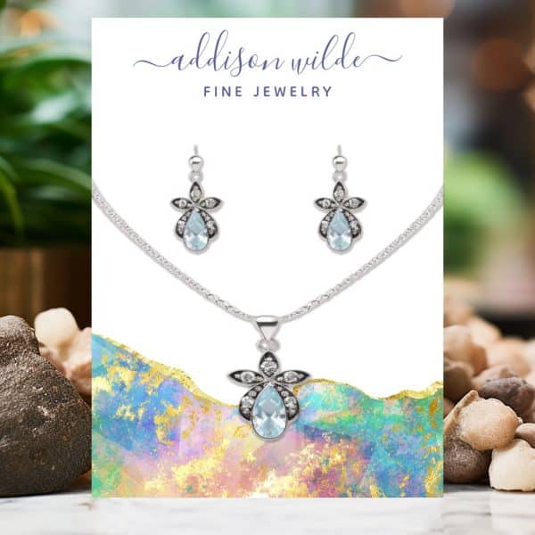Silver Necklace And Earrings Set With Light Blue Teardrop Gemstones And Small White Accents.