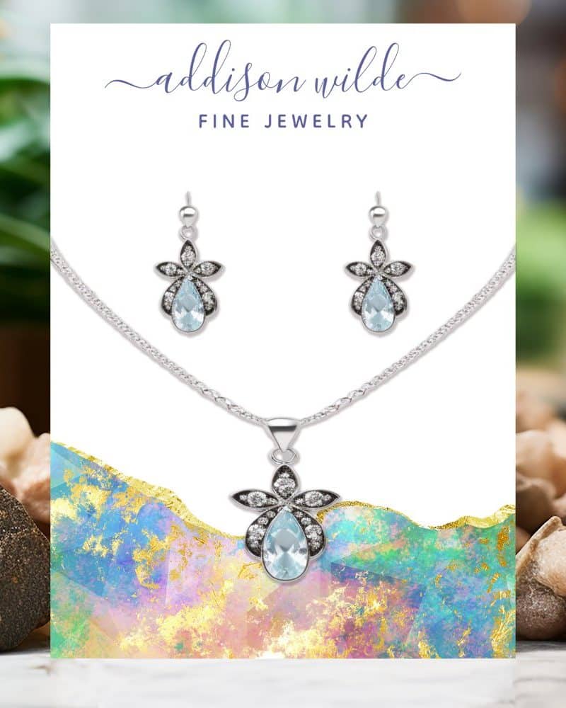 Silver necklace and earrings set with light blue teardrop gemstones and small white accents.