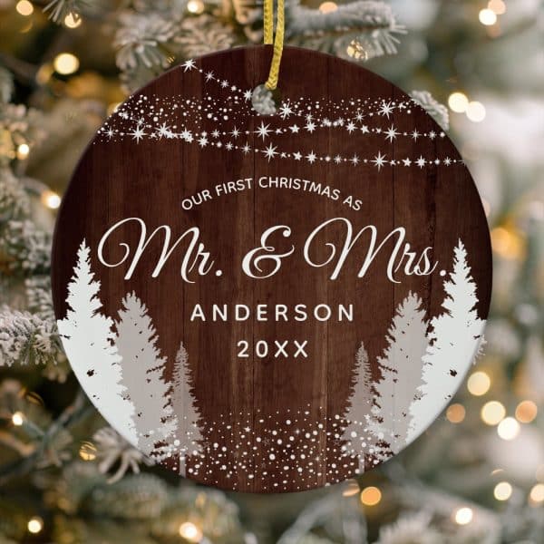 Round Christmas Ornament With A Wood Grain Background, Featuring A Snowy Winter Scene With Trees And The Text &Quot;Our First Christmas As Mr. &Amp; Mrs. Anderson 20Xx&Quot;.
