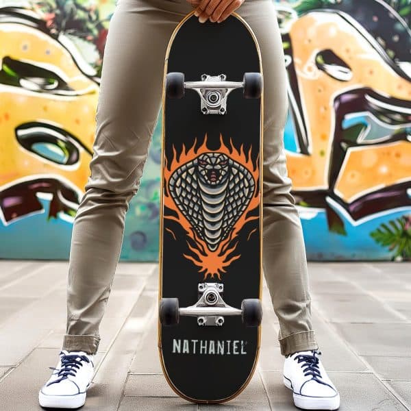 Person Holding A Skateboard With A Cobra In Flames Graphic.