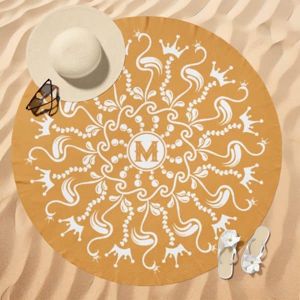 Mustard Yellow Round Beach Towel With A White Mandala Design Featuring Crowns And The Letter M In The Center.