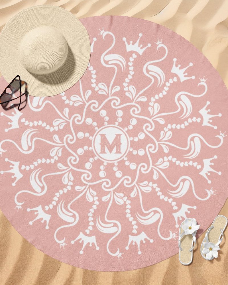 Pink round beach towel with a white mandala design and a central monogram.
