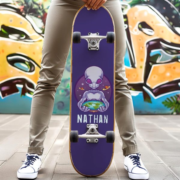 Person Holding A Purple Skateboard With An Alien Graphic Holding Earth And The Name Nathan.